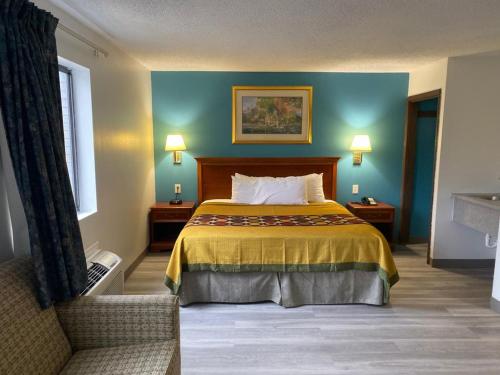 a hotel room with a bed and a chair at Americas Best Value Inn West Frankfort in West Frankfort
