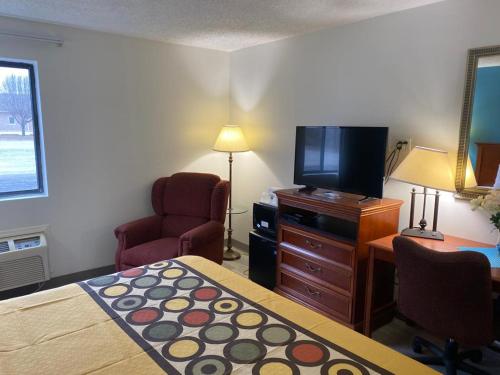 a hotel room with a bed and a television and a desk at Americas Best Value Inn West Frankfort in West Frankfort