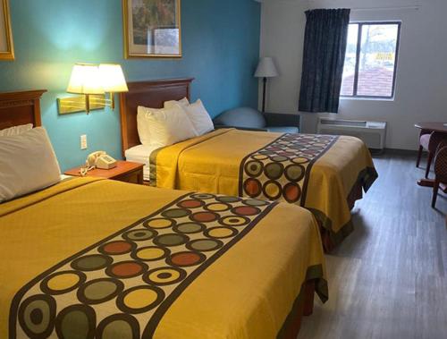 a hotel room with two beds with yellow covers at Americas Best Value Inn West Frankfort in West Frankfort