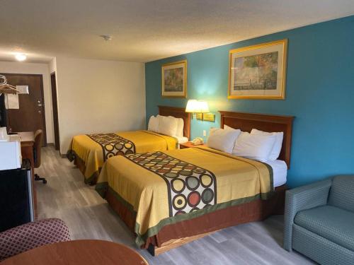 a hotel room with two beds and a chair at Americas Best Value Inn West Frankfort in West Frankfort