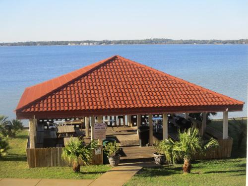 a building with an orange roof next to the water at Romantic condo for 2-Sunset Harbor Palms 1-205, pool, fishing pier in Navarre