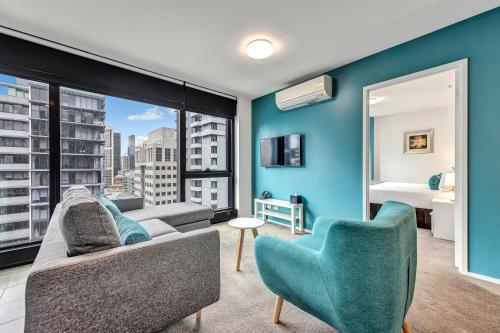 a living room with a couch and chairs and a large window at Pegasus Apart-Hotel in Melbourne