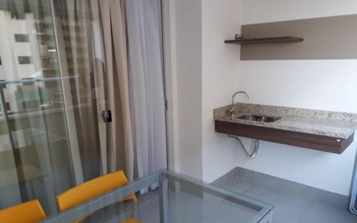 y baño con mesa de cristal y lavamanos. en Apartamento Resort em Olímpia, en Olímpia