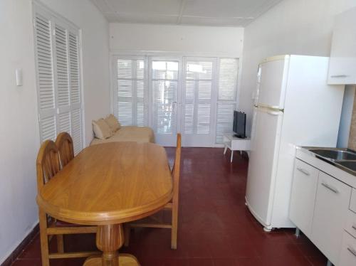 圖蓬加托的住宿－Departamento céntrico Tupungato，厨房配有木桌和冰箱。