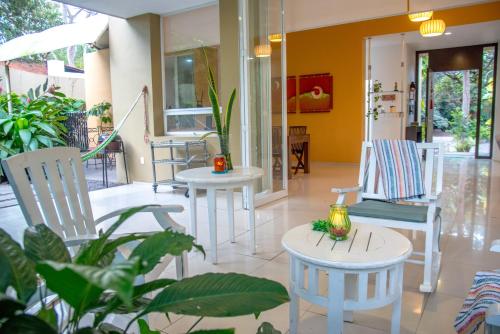 a lobby with white chairs and tables and plants at Htl & Villas Comala, alberca , parking, céntricas, Petfriendly in Comala