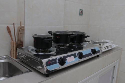 a stove with three pots on top of it at BERACA INN in Cotonou