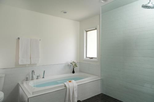 a white bathroom with a tub and a window at Silver Birches Resort in Hawley
