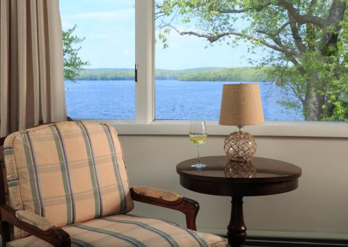 a chair and a glass of wine on a table in front of a window at Silver Birches Resort in Hawley