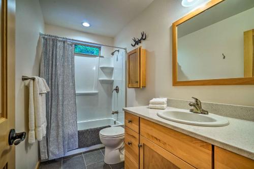a bathroom with a sink and a toilet and a mirror at Modern Beaver Valley Cabin with Hot Tub and Games! in Leavenworth
