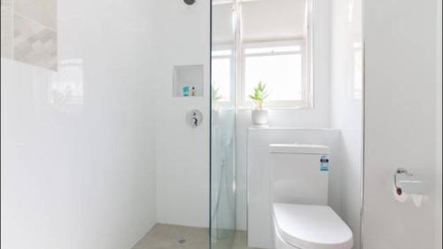 uma casa de banho branca com um WC e uma janela em B4 Crawley Apartment 1 BRM & Sleepout near UWA em Perth