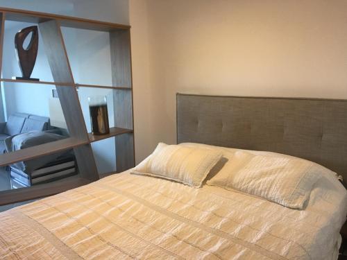 1 dormitorio con cama y espejo grande en Vistas, en Punta del Este