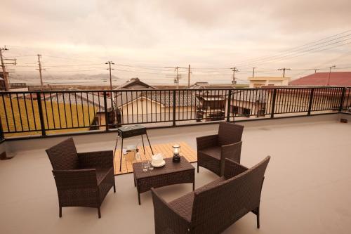 a patio with chairs and a table on a balcony at Awaji Portside Holiday Home CHOUTA - BBQ OK! - Self Check-In Only in Akashi