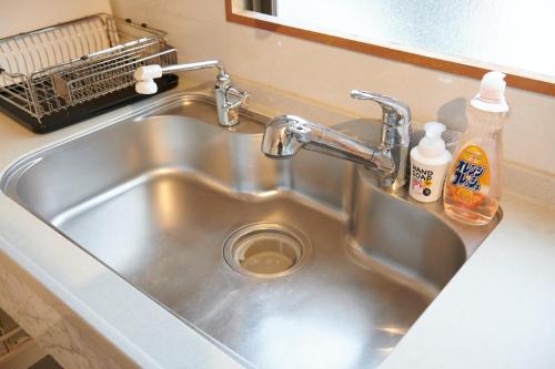a kitchen sink with two bottles of soap on it at Awaji Portside Holiday Home CHOUTA - BBQ OK! - Self Check-In Only in Akashi