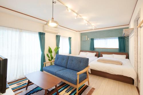 een slaapkamer met een bed en een blauwe stoel bij Awaji Portside Holiday Home CHOUTA - Self Check-In Only in Akashi