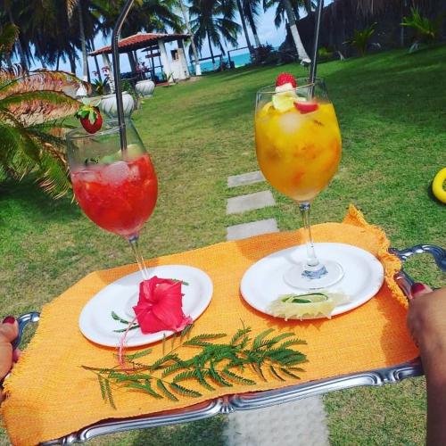 a table with two glasses of drinks on it at Parador Algaroba in Japaratinga