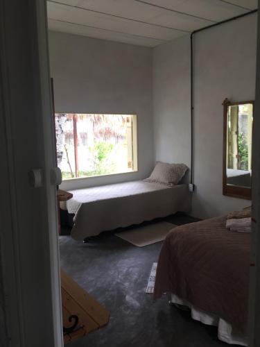 a bedroom with two beds and a window at Parador Algaroba in Japaratinga