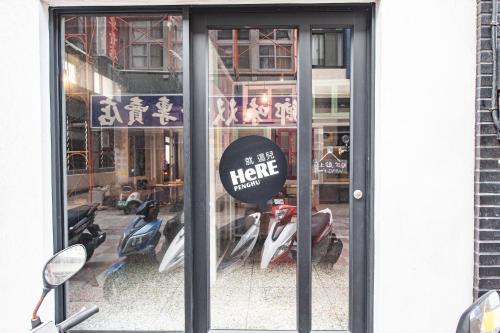 a store front door with a sign in the window at 澎湖 就這兒旅居 in Magong
