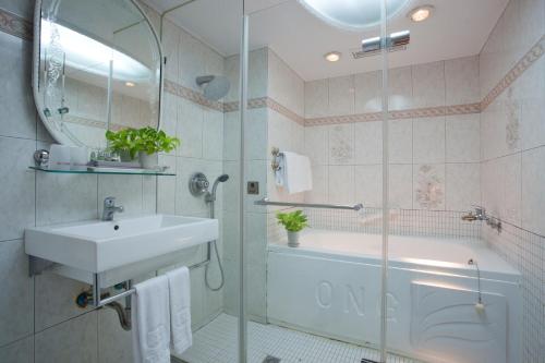 台北的住宿－豪悅大飯店，浴室配有水槽、淋浴和浴缸。