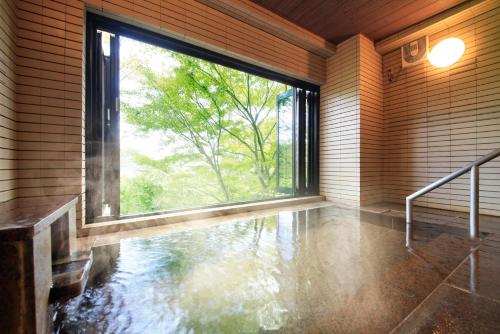 an empty room with a large window and water on the floor at Yutorelo-an ANNEX in Hakone