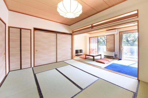 een woonkamer met schuifdeuren en een kroonluchter bij Yutorelo-an ANNEX in Hakone