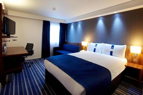 a hotel room with two beds and a television at Holiday Inn Express London - ExCel, an IHG Hotel in London