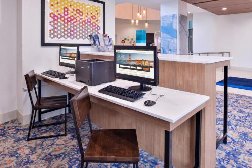 a desk with a laptop computer and a desktop computer at Holiday Inn Express New Orleans - St Charles, an IHG Hotel in New Orleans
