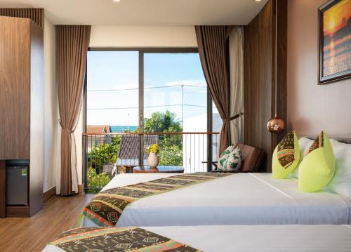 2 bedden in een kamer met een balkon bij Seaweed Luxury Villa & Spa in Hội An