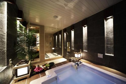 a bathroom with a tub and a sink and a mirror at Le Ciel Spa & Resort in Tsurugashima