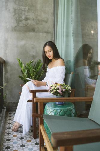 a woman sitting at a table writing on a paper at Paddy Boutique House Hoian in Hoi An