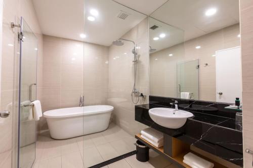 uma casa de banho com uma banheira, um lavatório e um WC. em Hotel 7 Suria em Kota Kinabalu