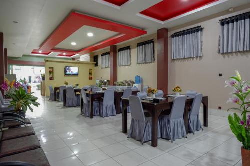 a banquet hall with tables and chairs in a restaurant at RedDoorz Syariah @ Hotel Wisma Indonesia Kendari in Kendari