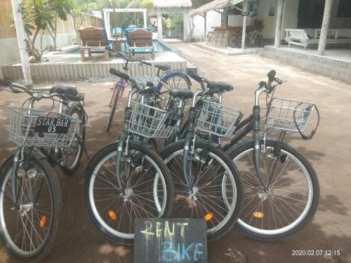 un grupo de bicicletas estacionadas junto a un cartel de alquiler de bicicletas en Star Bar and Bungalows, en Gili Air