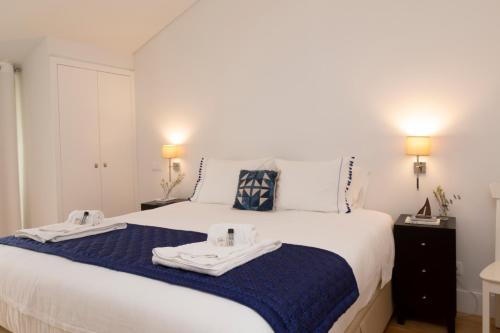 a bedroom with a bed with two towels on it at Tauro 195 near El Corte Ingles in Lisbon