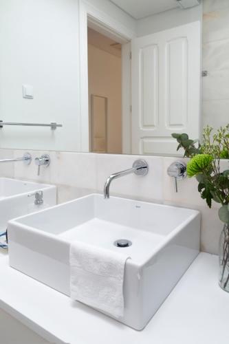 a white bathroom with a sink and a mirror at Tauro 195 near El Corte Ingles in Lisbon