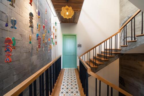 a hallway with stairs and a blue door at Paddy Boutique House Hoian in Hoi An