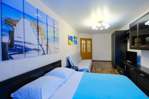 a bedroom with a blue bed and a couch at ОК! Советская, 69 №5 in Tomsk