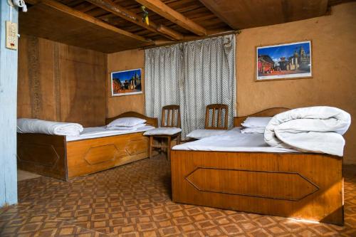 um quarto com duas camas e uma mesa e cadeiras em Homestay in Nagarkot em Thimi