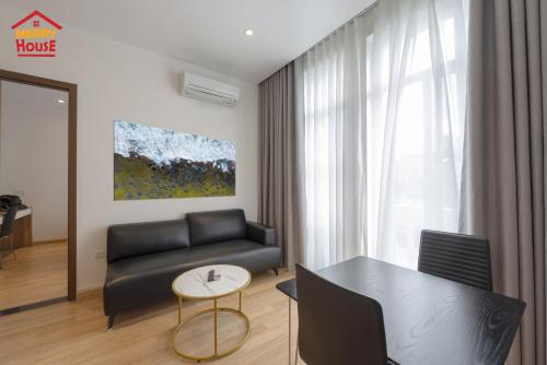 a living room with a couch and a table at Merry House Imperia in Hai Phong