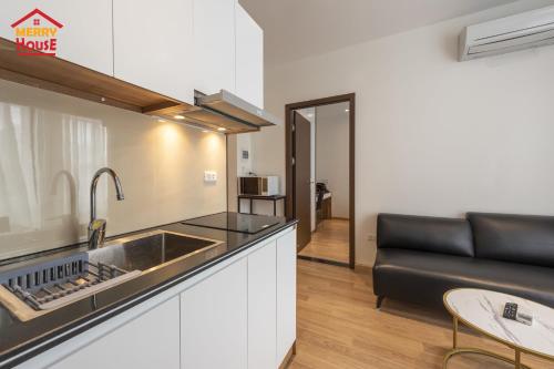 a kitchen with a sink and a couch in a room at Merry House Imperia in Hai Phong