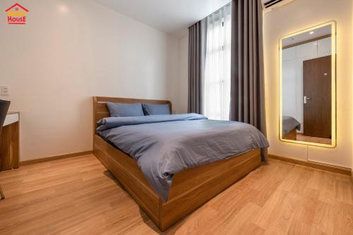 a bedroom with a bed and a large mirror at Merry House Imperia in Hai Phong