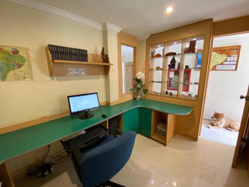 a office with a green desk with a computer on it at Hostal de La Mancha in Quito