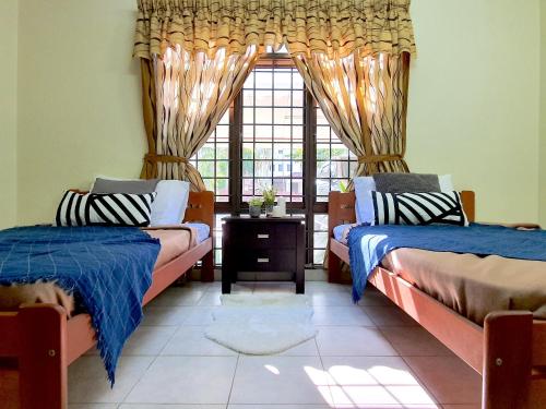 a bedroom with two beds and a window at A famosa Resort Villa with private pool by BeeStay 10 pax in Kampong Alor Gajah