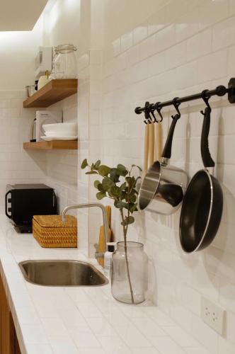 a kitchen sink with pots and pans hanging on a wall at Marlowe-Tony's home in Bangkok