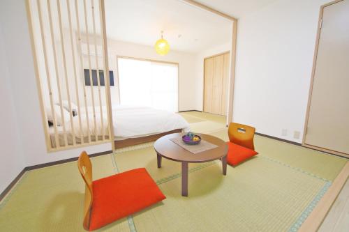 a bedroom with a bed and a table and chairs at Apartment HOTEL KIRO Kyoto STATION in Kyoto