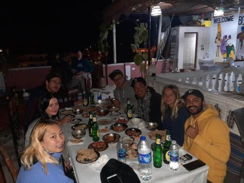 a group of people sitting around a table with food at Luxor hotel Bella Vista Apartments and Hotel in Luxor