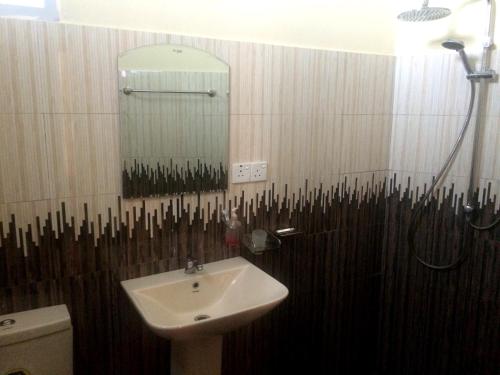 a bathroom with a sink and a mirror at The Mist Holiday Bungalow in Haputale