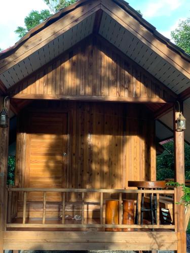 a wooden gazebo with a table in it at Taluangjit Resort&Garden in Khiriwong