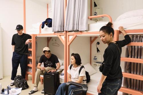 a group of people in a room with bunk beds at TG Hostel - stay together in Taichung