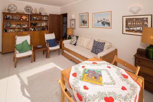 - un salon avec une table et un canapé dans l'établissement Barra Beach House - Praia da Barra, à Praia da Barra