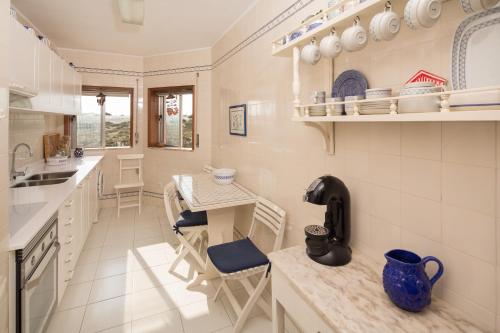 a kitchen with a counter and a table with chairs at Barra Beach House - Praia da Barra in Praia da Barra